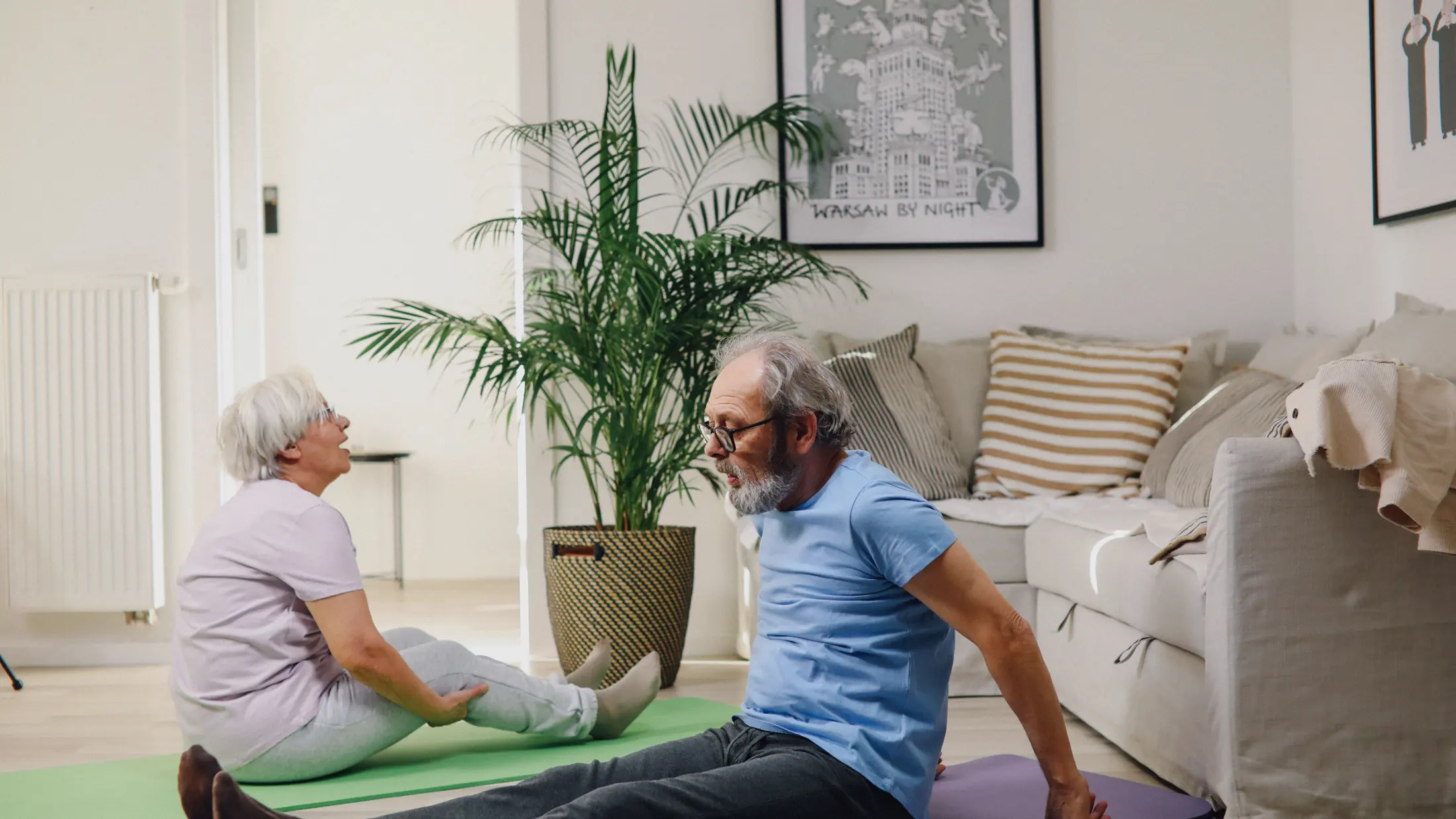 Couple de seniors faisant des exercices au sol dans leur salon