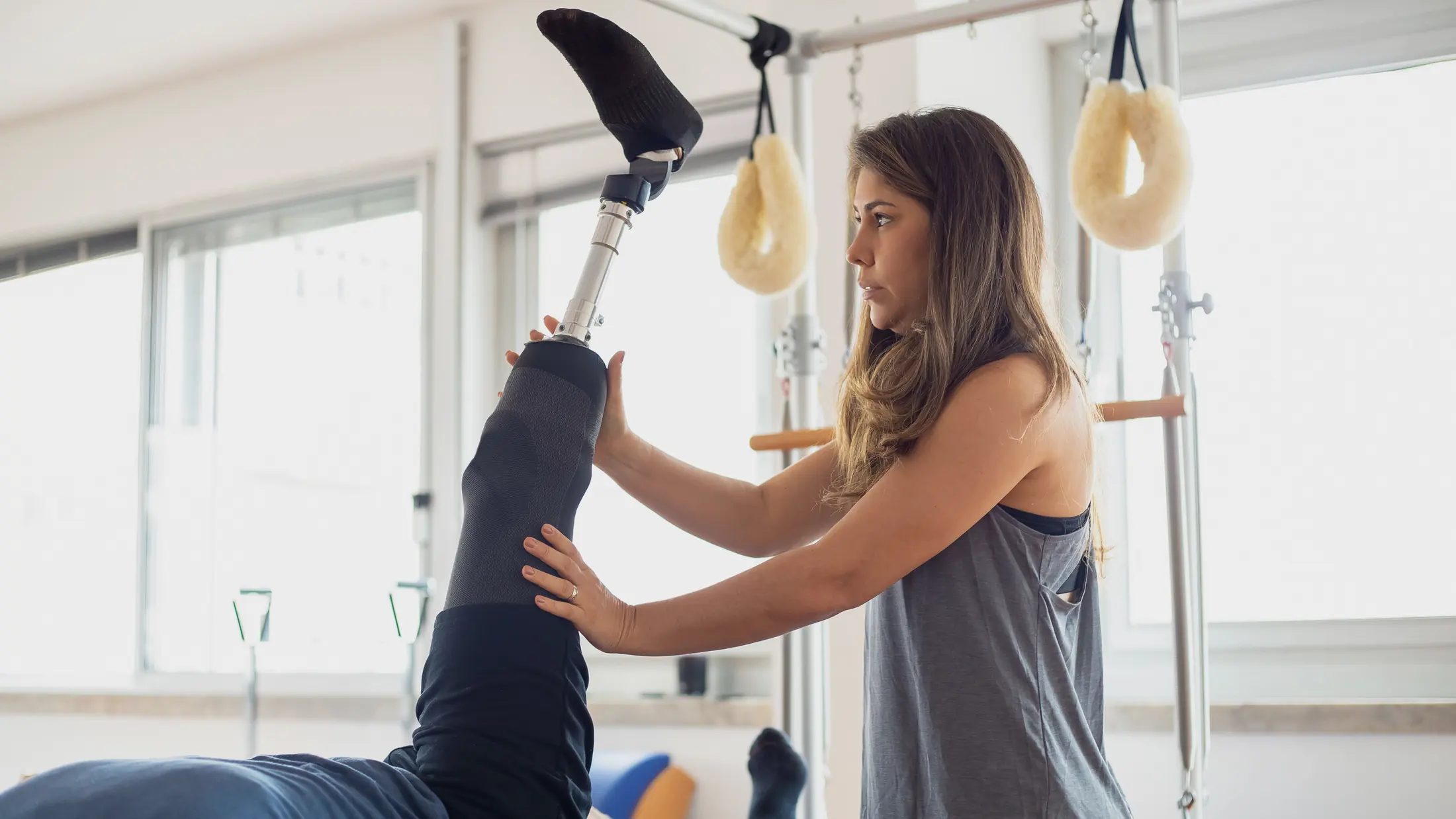 Professionnelle accompagnant un exercice avec une personne appareillée