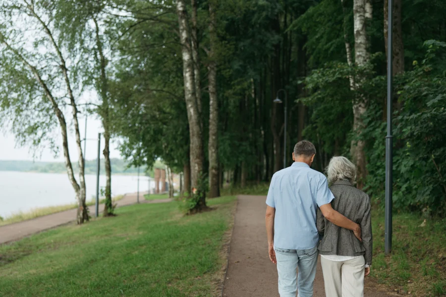 Couple de seniors marchant sur un chemin au bord de l'eau