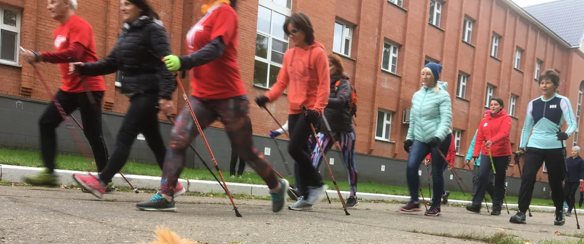 Groupe de marche nordique en pleine séance, bâtons poussés vers l'arrière
